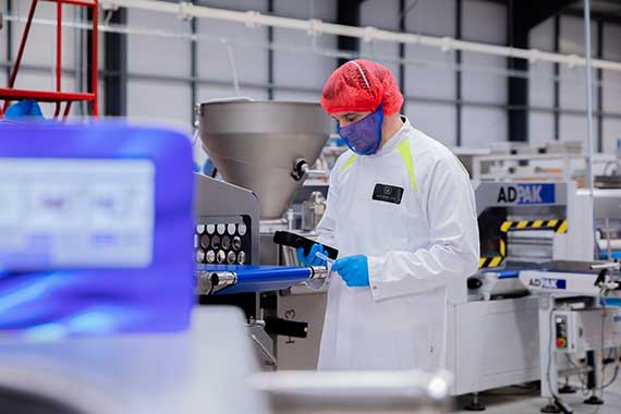 man in protective clothing working in food production area
